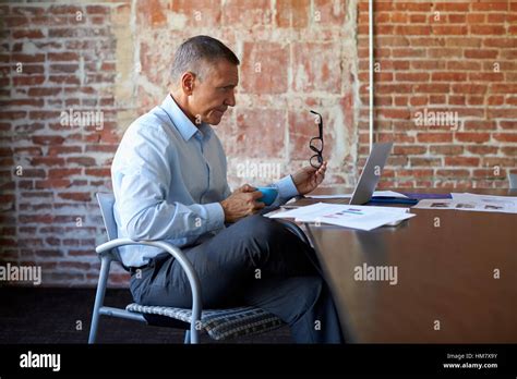 Mature Businessman Working On Laptop In Boardroom Stock Photo Alamy