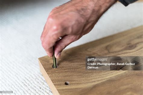 A Man Assembling Wooden Furniture Installing Screws And Nutsbolts High