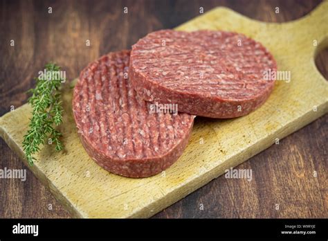 Raw Beef Ground Steaks On A Cutting Board Stock Photo Alamy