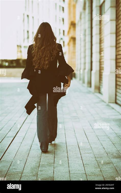 Woman Walking Away On The Street Stock Photo Alamy