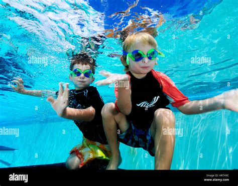 Kids swimming underwater in pool enjoying the relaxation of summer ...