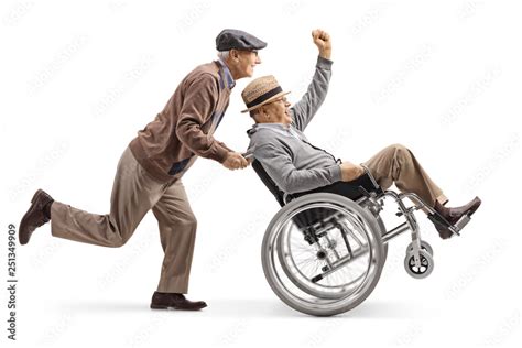 Senior Man Pushing A Positive Disabled Man In A Wheelchair Gesturing