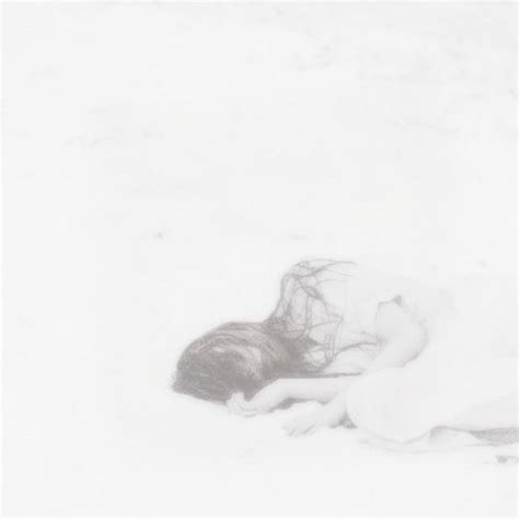 A Black And White Photo Of A Woman Laying In The Snow With Her Head Down