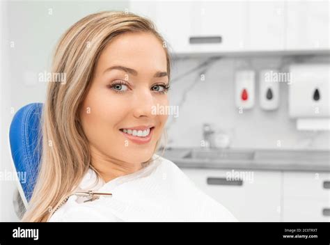 Young Smiling Woman Sitting On Chair At Dentist Office Dental Care