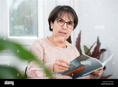 Mature Brunette Woman Reading A Magazine Stock Photo Alamy