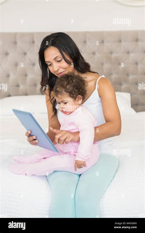 Smiling Brunette Holding Her Baby And Using Tablet Stock Photo Alamy