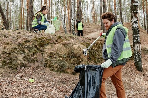 Premium Photo Volunteer Picking Up Garbage In Park