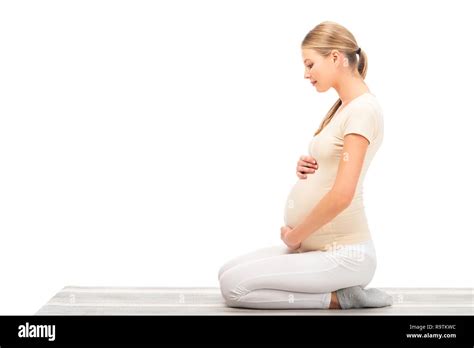 Pregnant Blonde Woman Sitting On Floor In Profile Isolated On White