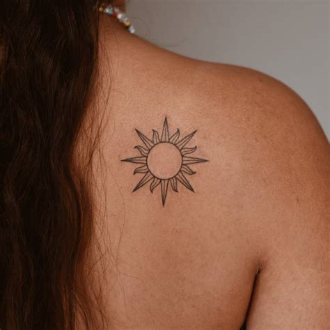 Sun Tattoo Located On The Shoulder Blade