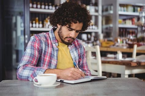 Premium Photo Man Writing On A Diary