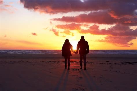 Sombras En La Puesta De Sol Silueta De Una Pareja Paseando Por La Playa