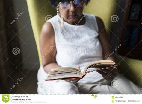 Livro De Leitura Superior Da Mulher Na Sala Foto De Stock Imagem De