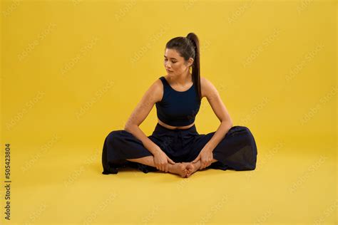 Pretty Girl Sitting In Butterfly Ii Yoga Pose With Closed Eyes And Turned Head While Exercising