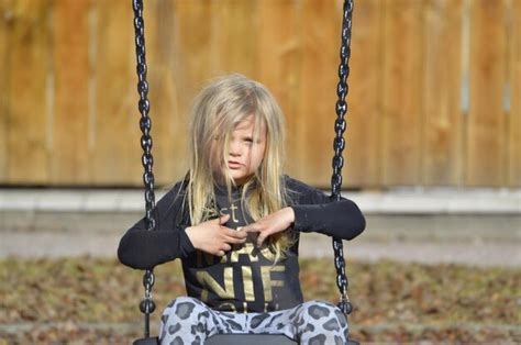 Premium Photo Portrait Of Cute Girl Sitting On Swing In Playground