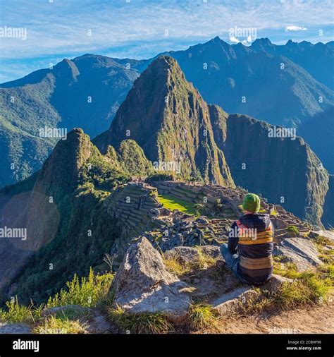 Tourist contemplating the Machu Picchu inca ruin at sunrise after the ...