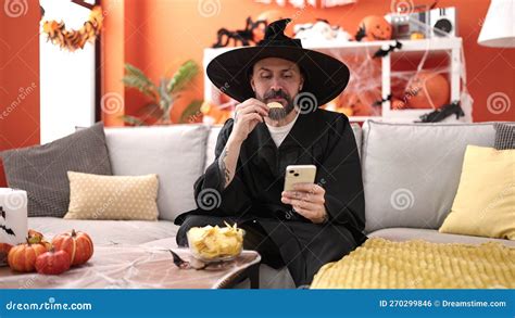 Young Bald Man Wearing Wizard Costume Eating Chips Potatoes Using