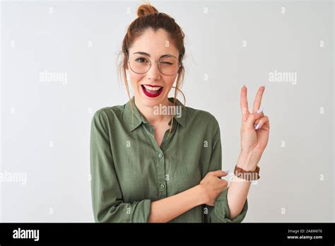 Redhead Woman Wearing Green Shirt And Glasses Standing Over Isolated