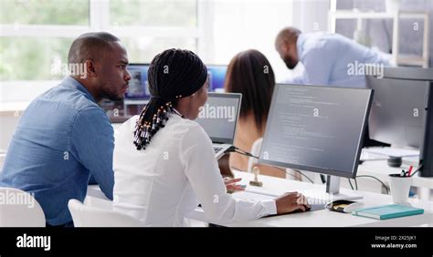 Working African Business Team Of Programmers Coding On Computer Stock