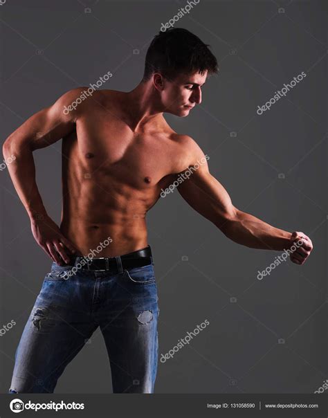 Torso Of Shirtless Man In Jeans Posing On Gray Background Stock Photo