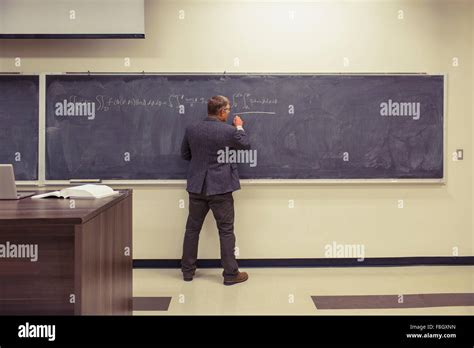 Caucasian Teacher Writing On Chalkboard Stock Photo Alamy