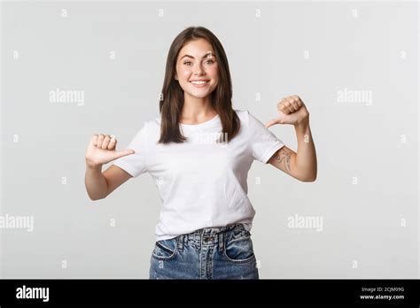 Excited Happy Brunette Girl Smiling Pointing Fingers At Your Logo Showing Banner Stock Photo