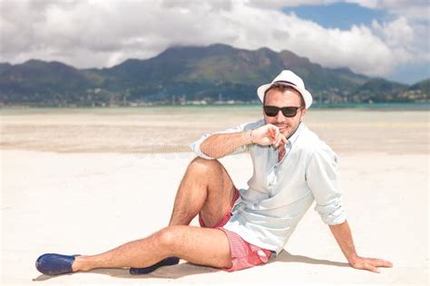 Homem Novo Pensativo Que Senta Se Na Praia Imagem De Stock Imagem De