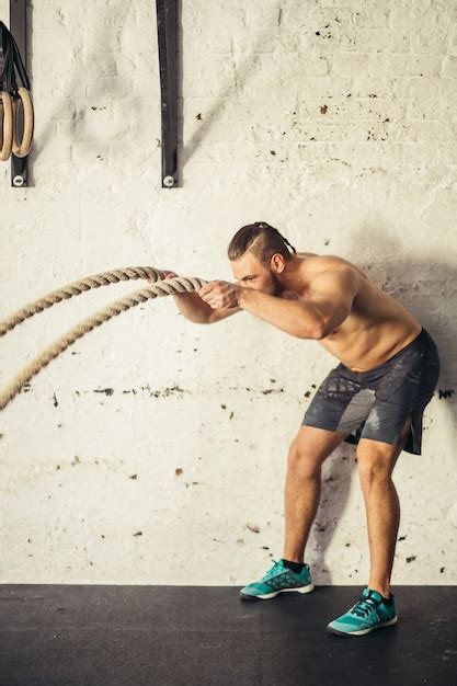 Premium Photo Man With Battle Ropes Exercising In Fitness Gym