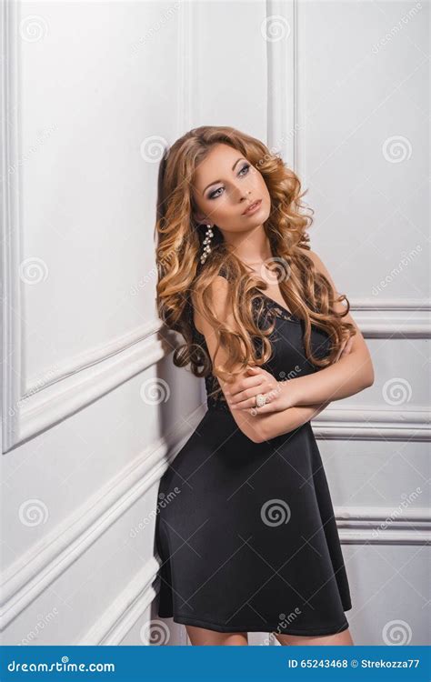Verticale De Belle Jeune Fille Blonde Dans La Robe Noire Photo Stock