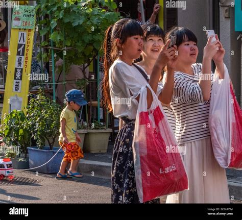 Japanese Girls Taking Pictures With Their Smartphone At Shitamachi