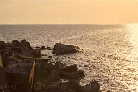 Seascape With Large Concrete Breakwaters At Beautiful Orange Sunset