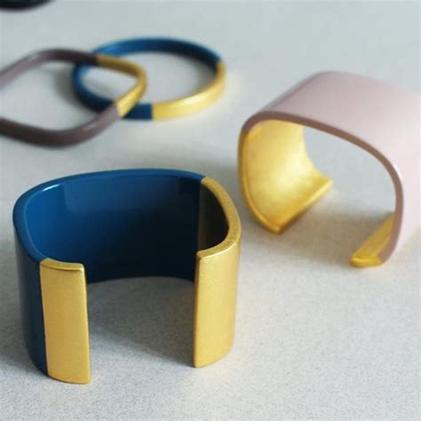 Three Different Colored Bracelets Sitting On Top Of A White Table Next