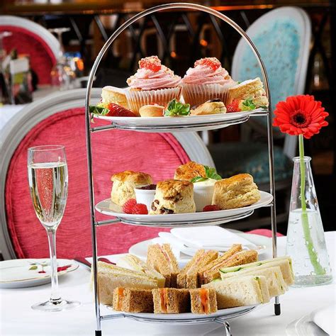 Three Tiered Trays Filled With Pastries And Desserts On Top Of A Table