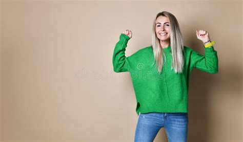 Portrait Of Smiling Woman With The Fists Up Against A Nude Background Stock Photo Image Of