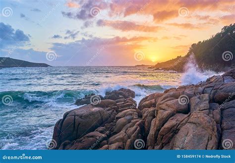 Sunset Of The Sea With Rocks And Mountain In The Background Beach And