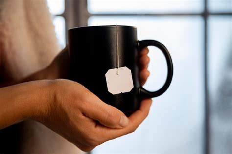 Free Photo Person Holding A Cup Of Hot Tea Close Up