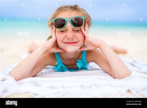 Adorable Little Girl Lying On A Beach Towel During Summer Vacation