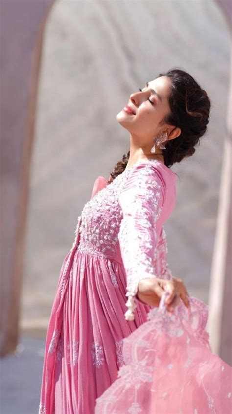 A Woman In A Pink Dress Is Looking Up