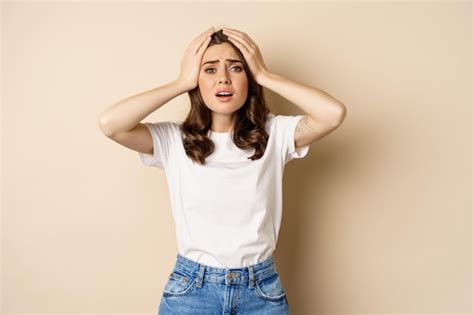 Free Photo Young Woman Facing Disaster Looking Anxious In Panic Holding Hands On Head