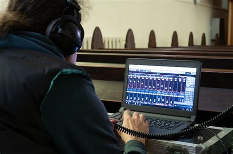 Premium Photo A Sound Engineer With Headphones Sits In Front Of A