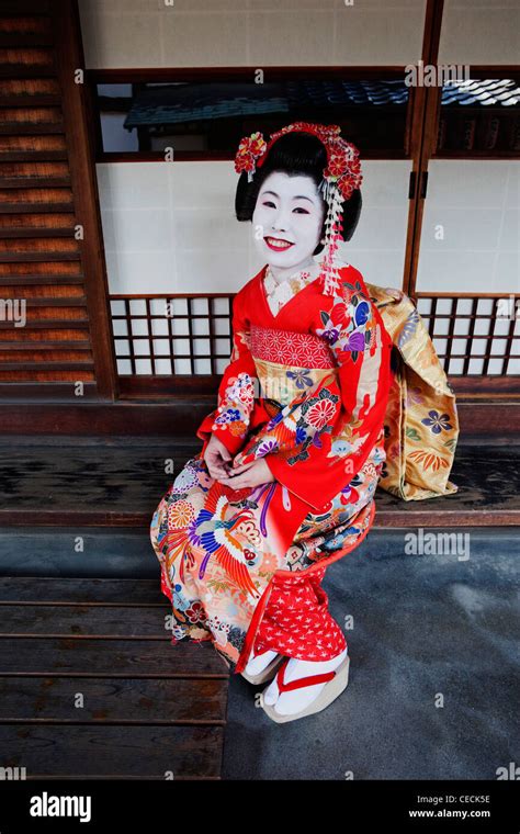 Geisha In Red Kimono Sitting In Front Of House Stock Photo Alamy