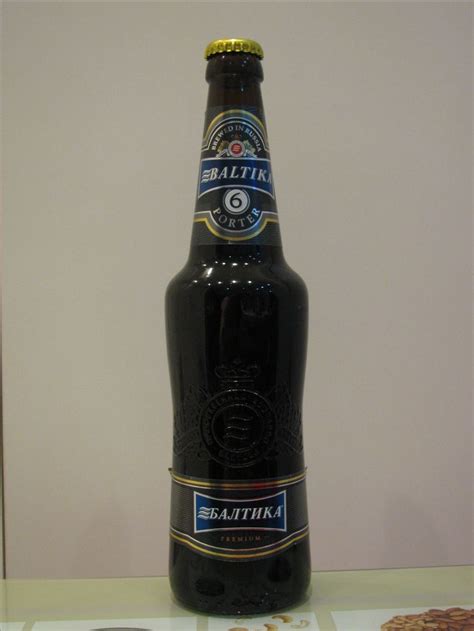 a bottle of beer sitting on top of a table next to a plate of cookies