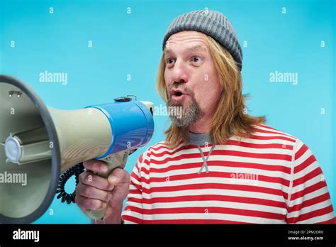 Mature Man In Striped Shirt Shouting In Bullhorn To Announce