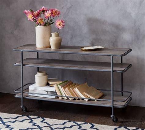 A Shelf With Books And Vases On It Next To A Rug In A Room