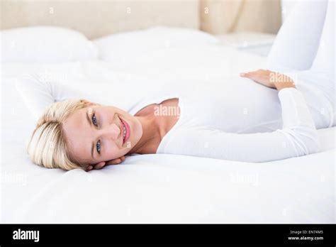 Smiling Blonde Woman Lying On The Bed Stock Photo Alamy