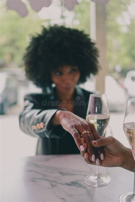 Multiracial Female Couple Drinking And Celebrating In A Bar Stock Image