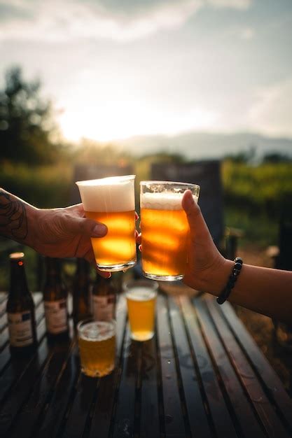 Un Grupo De Amigos Felices Bebiendo Y Brindando Cerveza Foto Premium