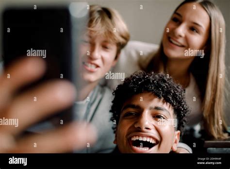 Cheerful Teenage Male And Female Friends Taking Selfie With Mobile