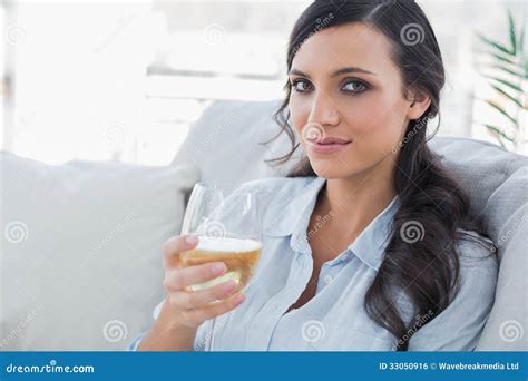 Pretty Brunette Drinking White Wine Sitting On Sofa Stock Photo Image