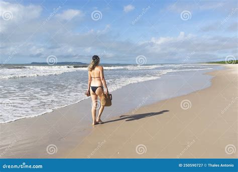 Woman In Bikini Walking On Beach Sand Against Blue Sky Stock Image