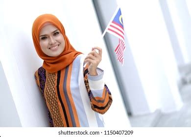 Muslim Woman Happy Holding Malaysian Flag Stock Photo